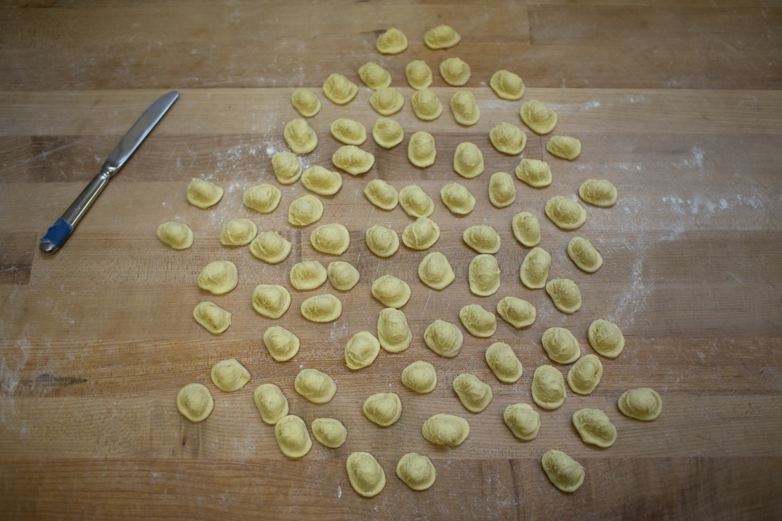 fresh housemade orecchiette pasta on the wood shaping table in the runner and stone bakery