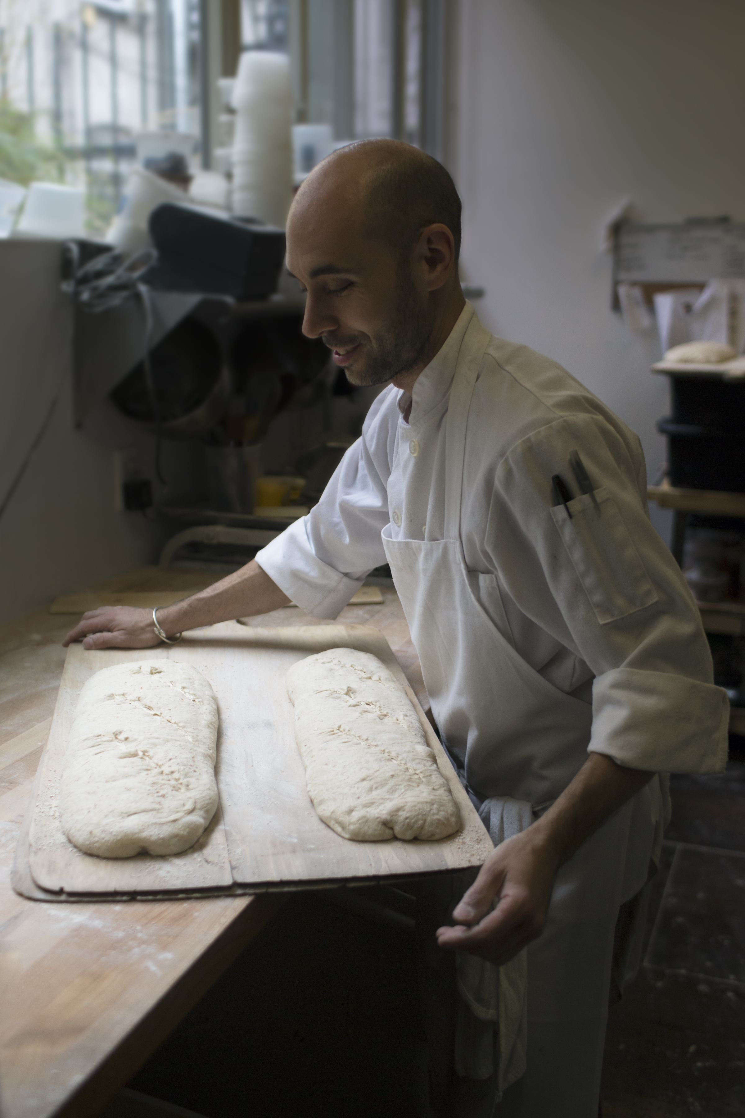 peter endriss loading two large loaves into the oven at runner &amp; stone