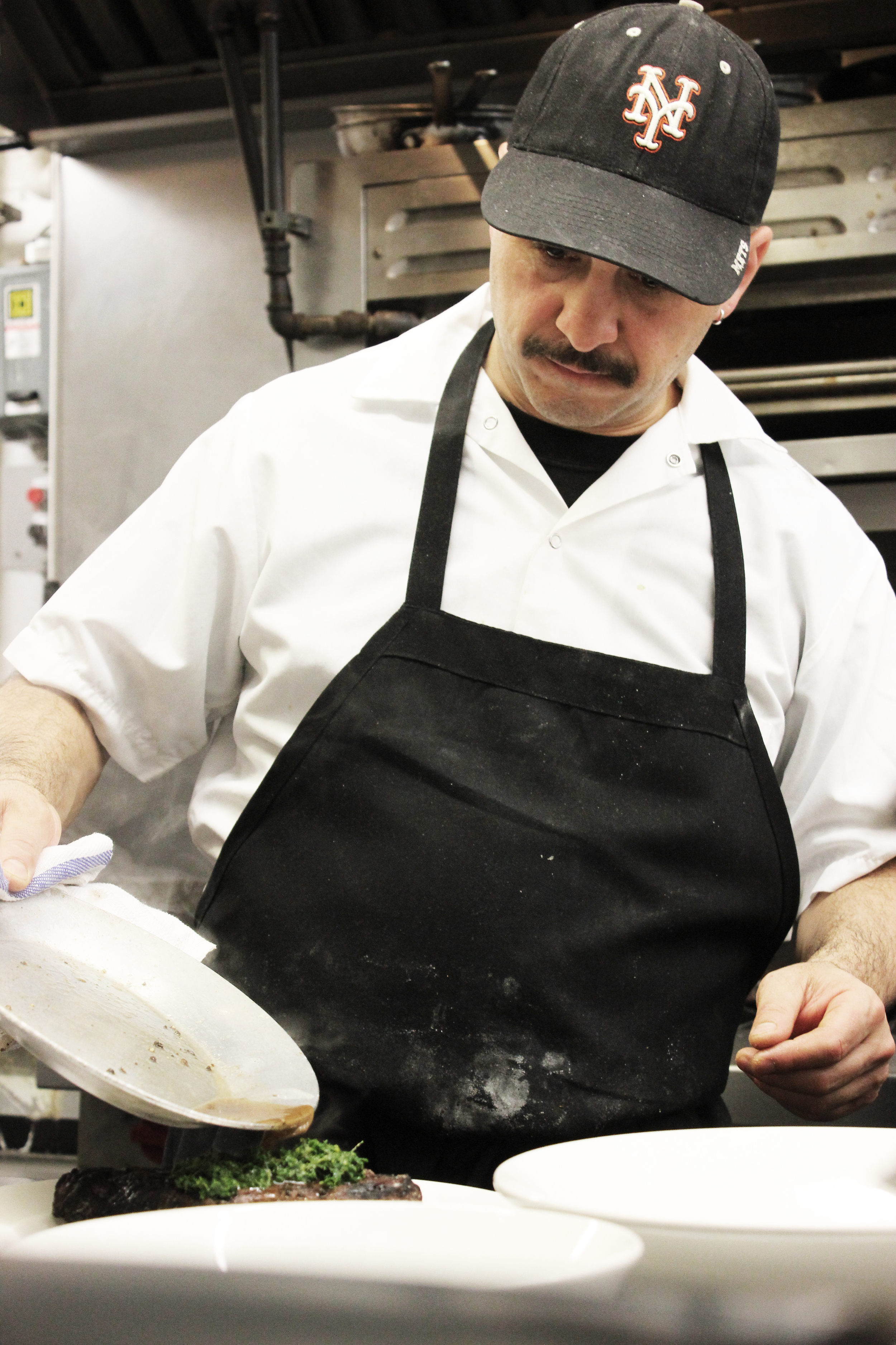 chef chris pizzulli plating food in the kitchen