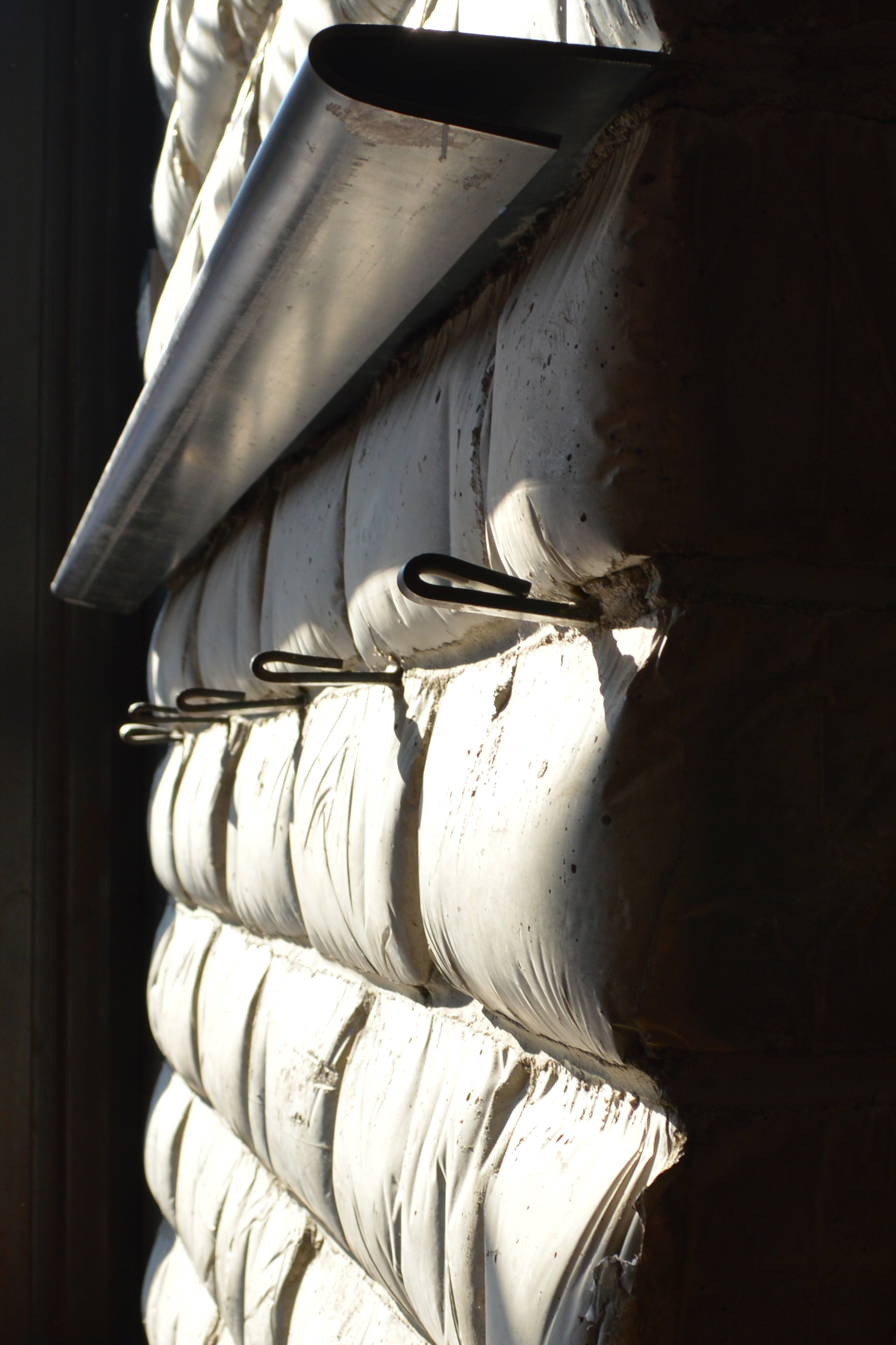 the interior wall at runner and stone showing concrete masonry units ("belly blocks") formed in flour bags, giving them the look of soft pillows