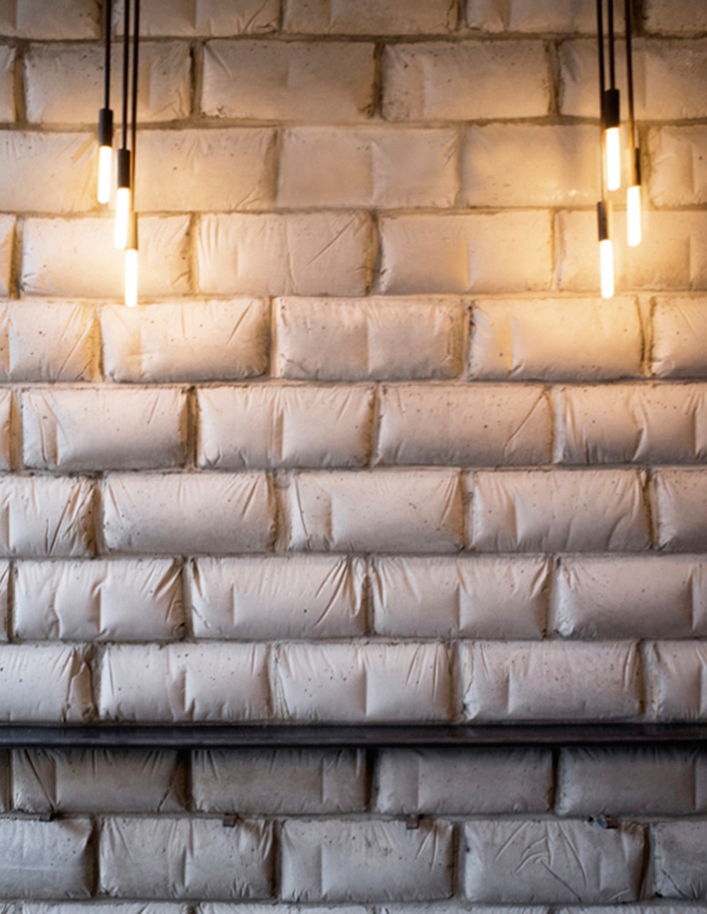 the interior wall at runner and stone showing concrete masonry units ("belly blocks") formed in flour bags, giving them the look of soft pillows