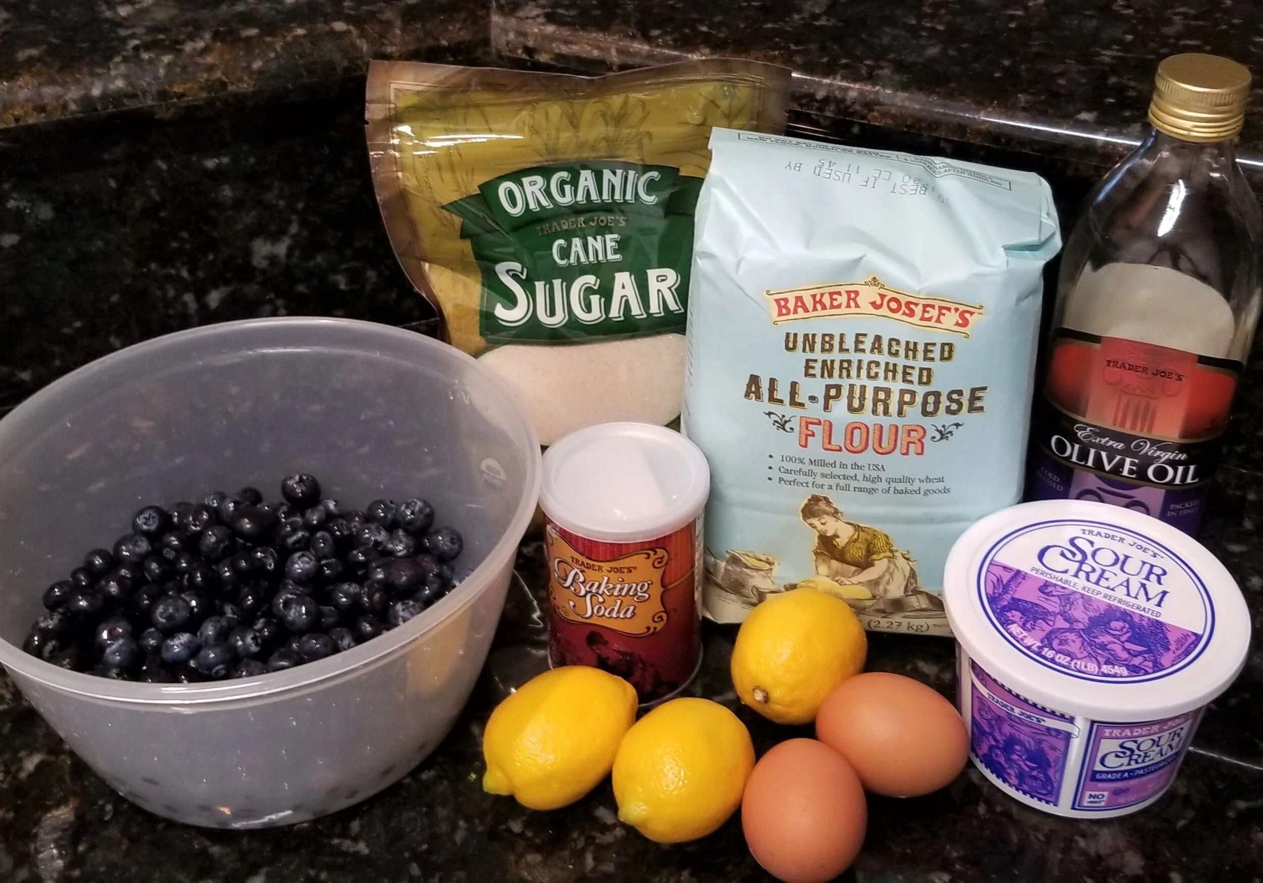 sugar, lemon, eggs, blueberries, cornstarch and sour cream on a counter