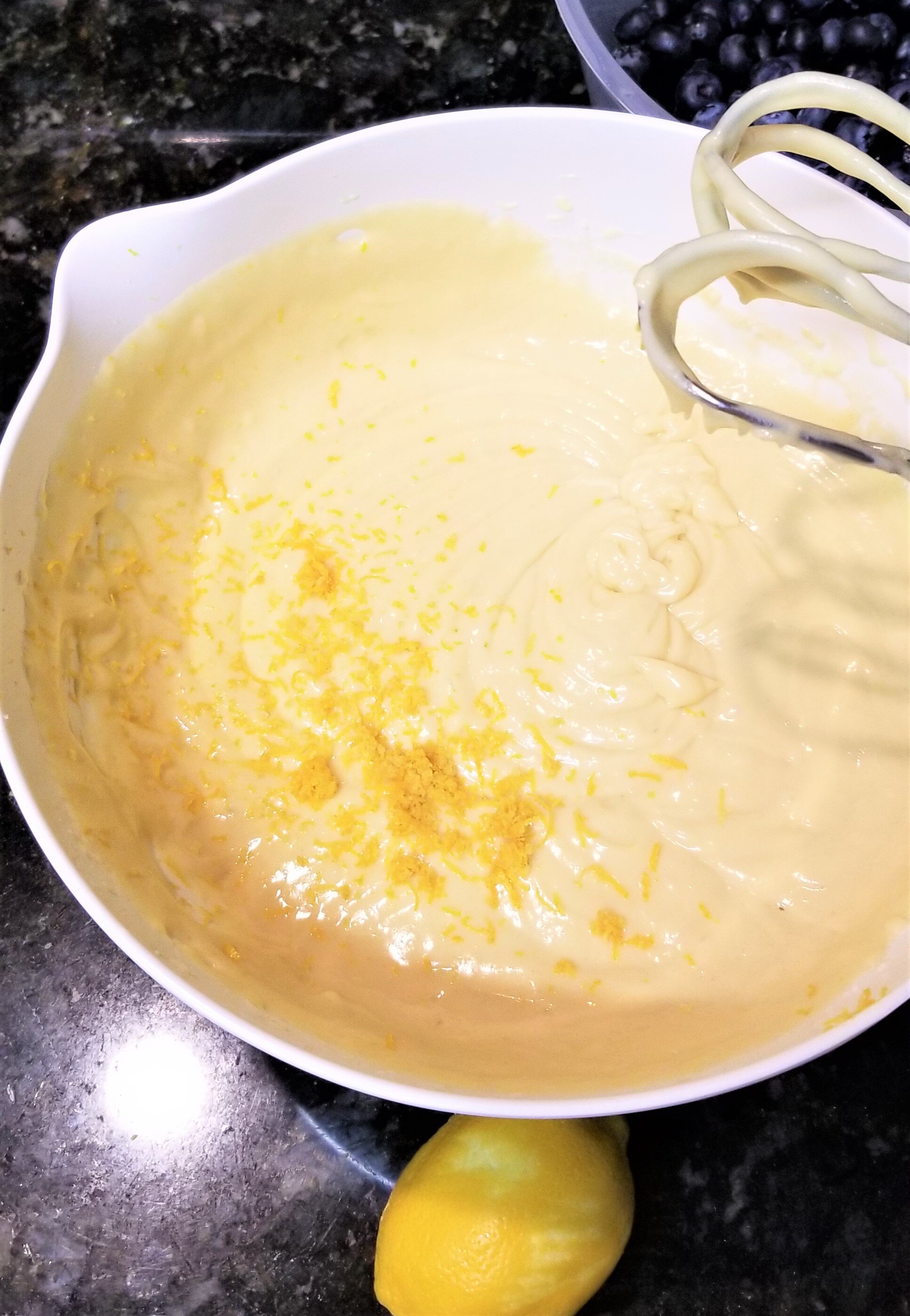 Adding lemon zest to a cake batter with an electric mixer