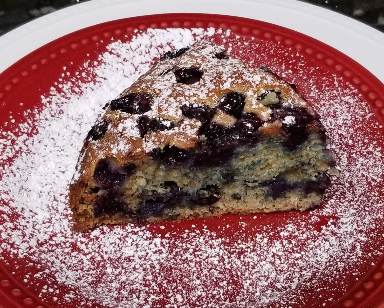 Slice of blueberry lemon cake on a red plate