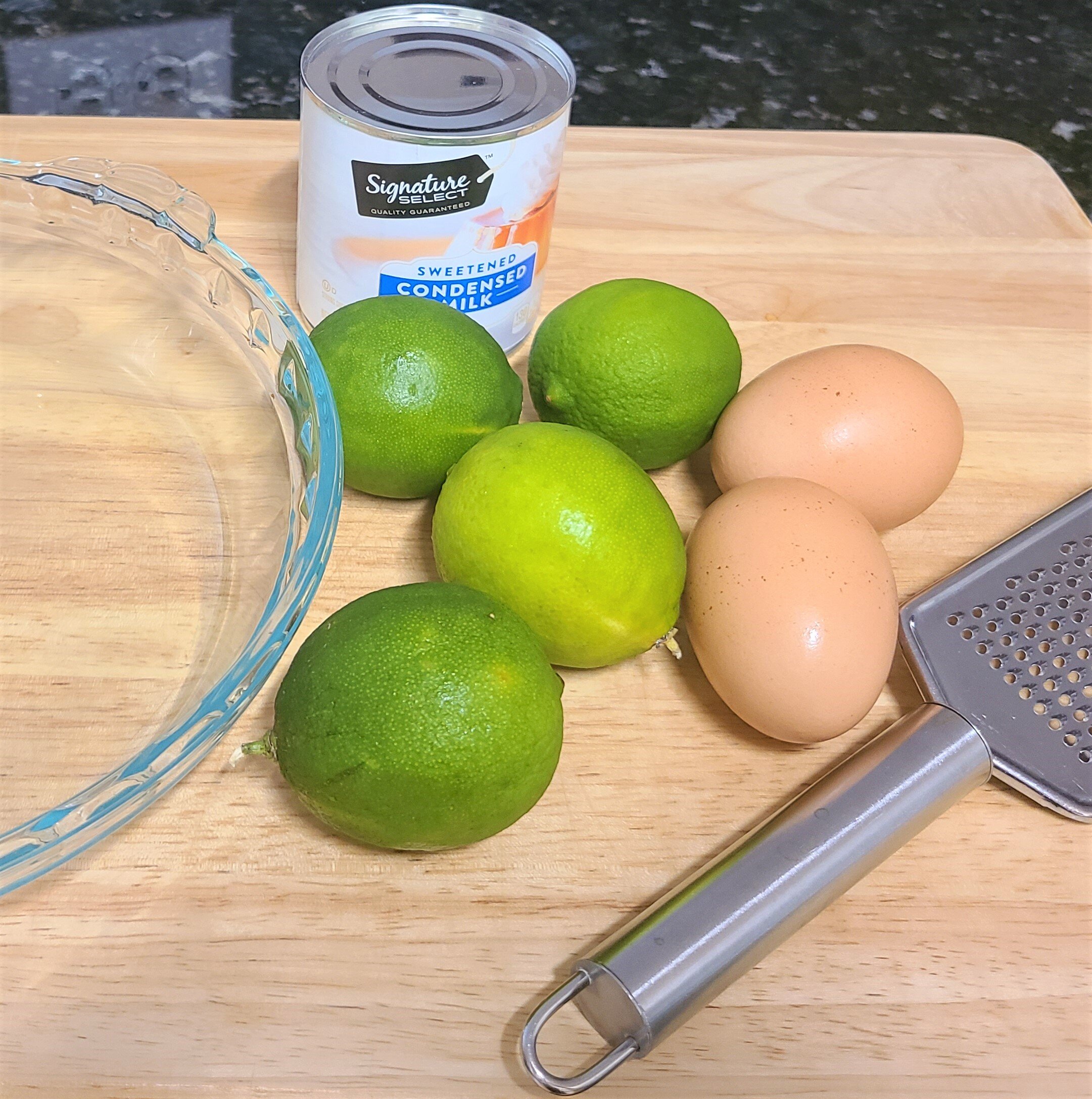 limes, eggs on a wooden cutting board