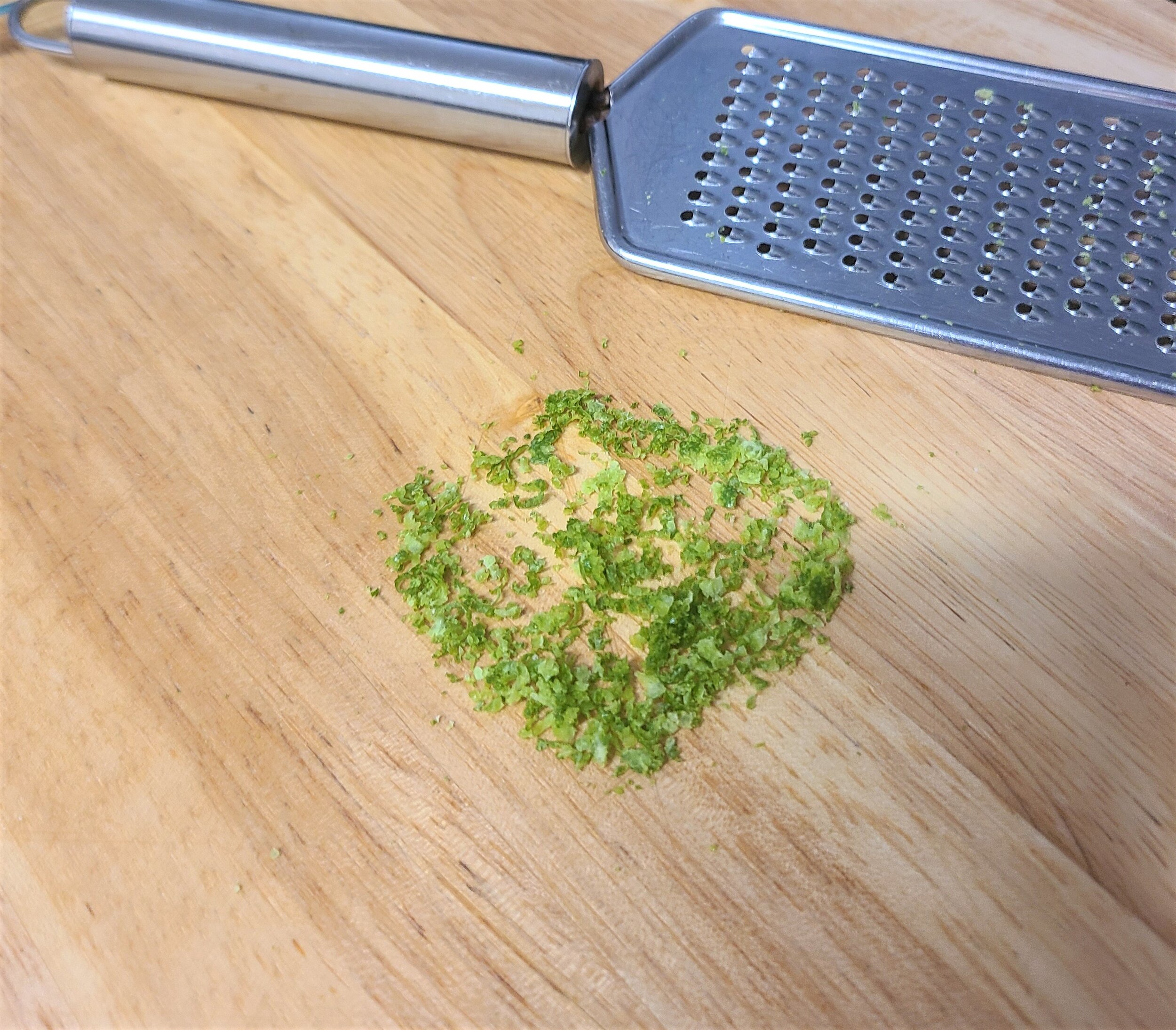 lime zest on a wooden cutting board