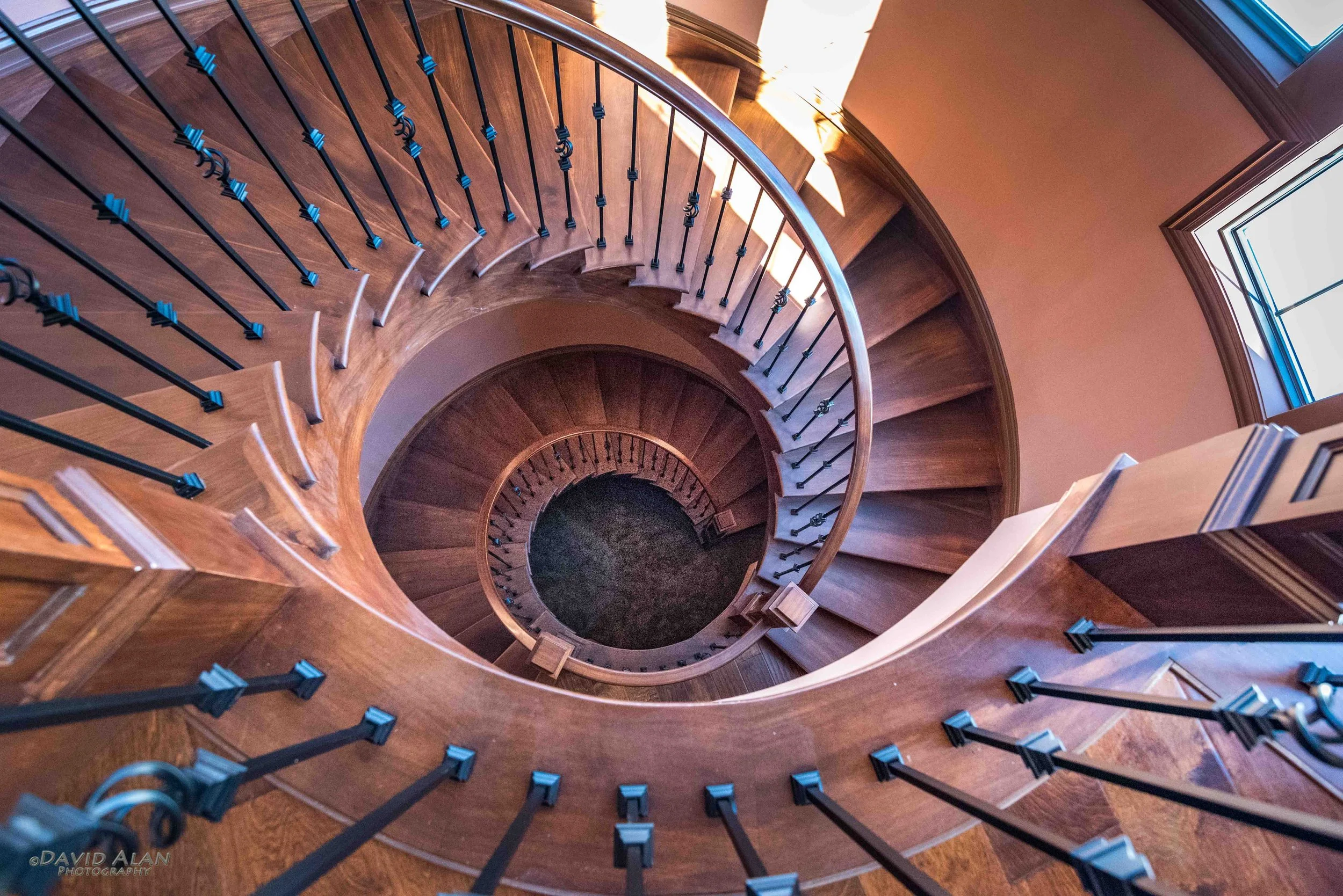 Custom home spiral staircase with wood and iron railing built by Perrino Builders in Northeast Ohio