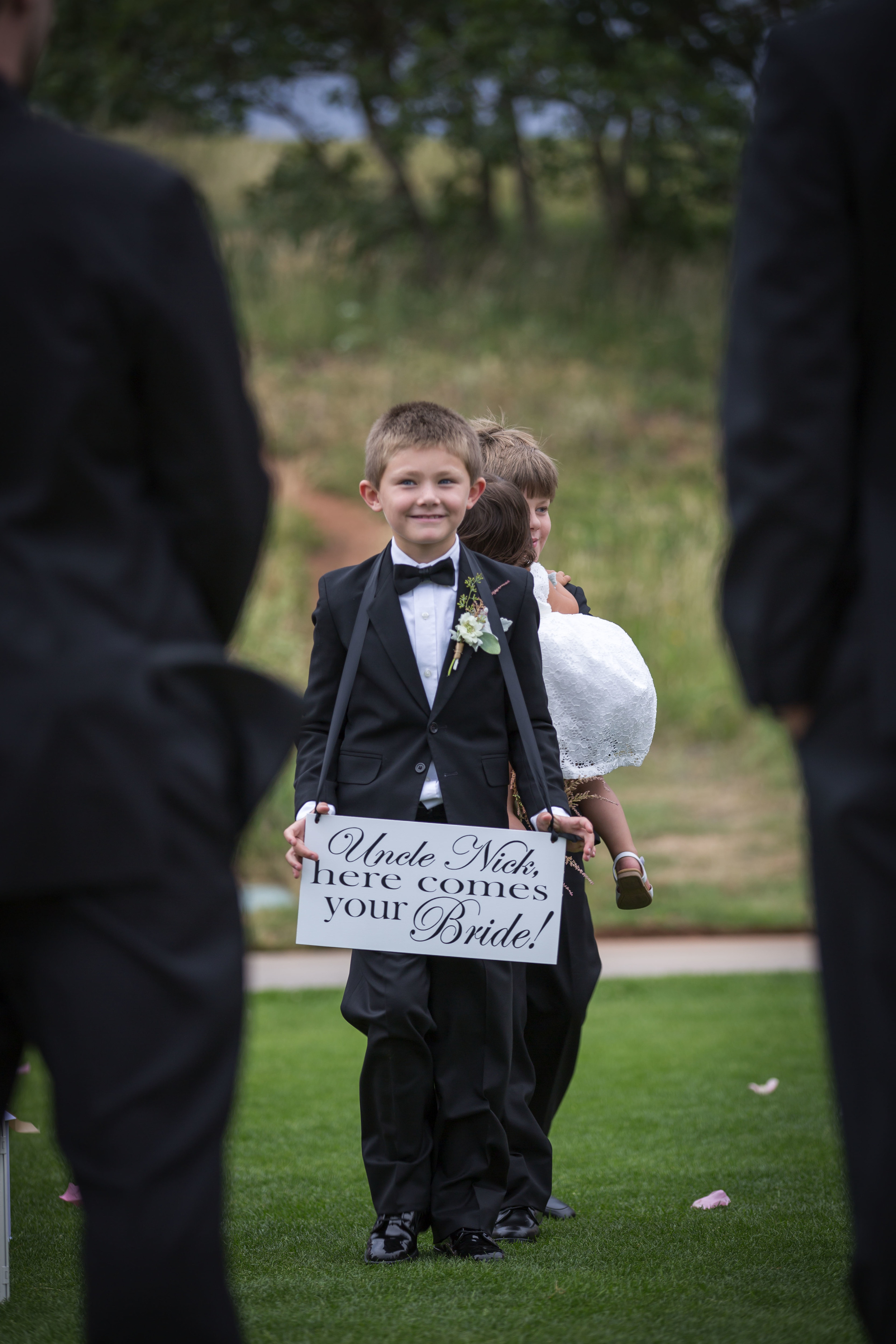 My nephew carried a sign that said.... "uncle nick, here comes your bride". ordered off etsy