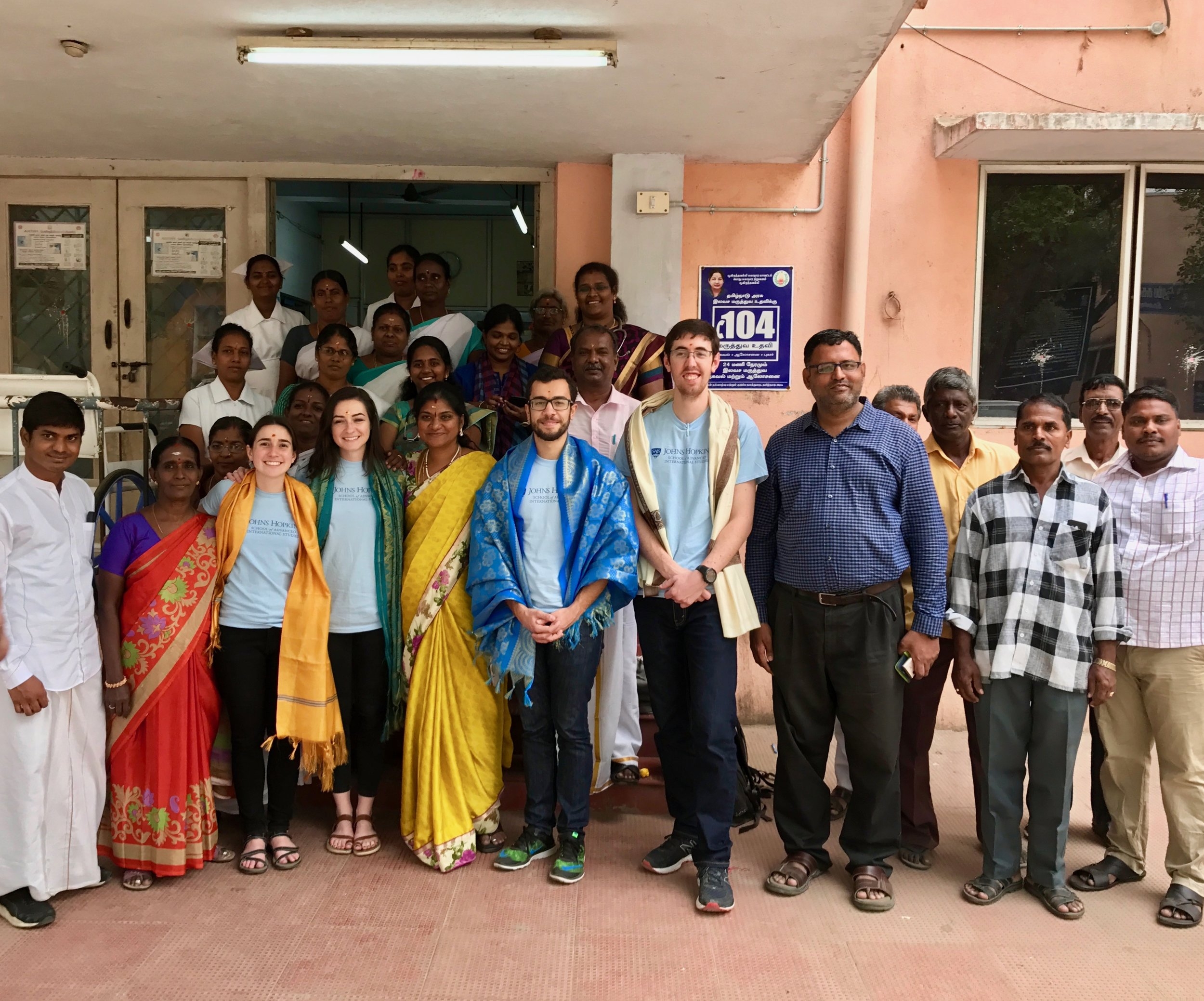  The Chennai, India IDEV Practicum Team gathers with doctors, nurses, and staff outside the Poonamallee urban primary health center (PHC)&nbsp;following interviews and observations.&nbsp;The PHC staff presented colorful scarves to the team as they we