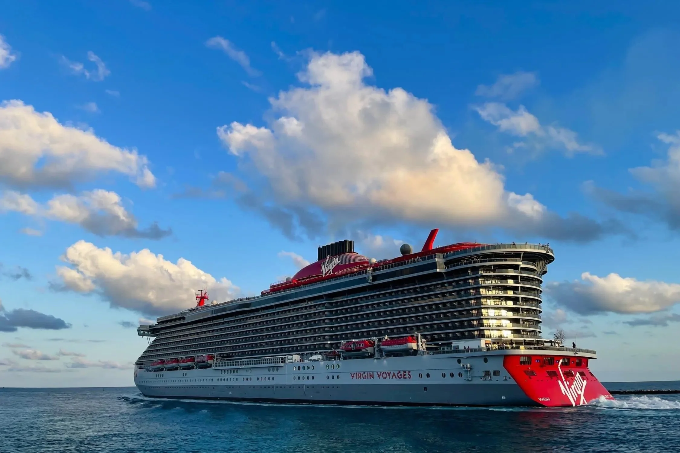 Virgin-Voyages-cruise-ship-Scarlet-Lady-leaves-the-Port-of-Miami-at-sunset-for-a-cruise-out-on-the-Atlantic-Ocean-under-a-blue-sky-with-a-few-clouds-scaled.jpeg