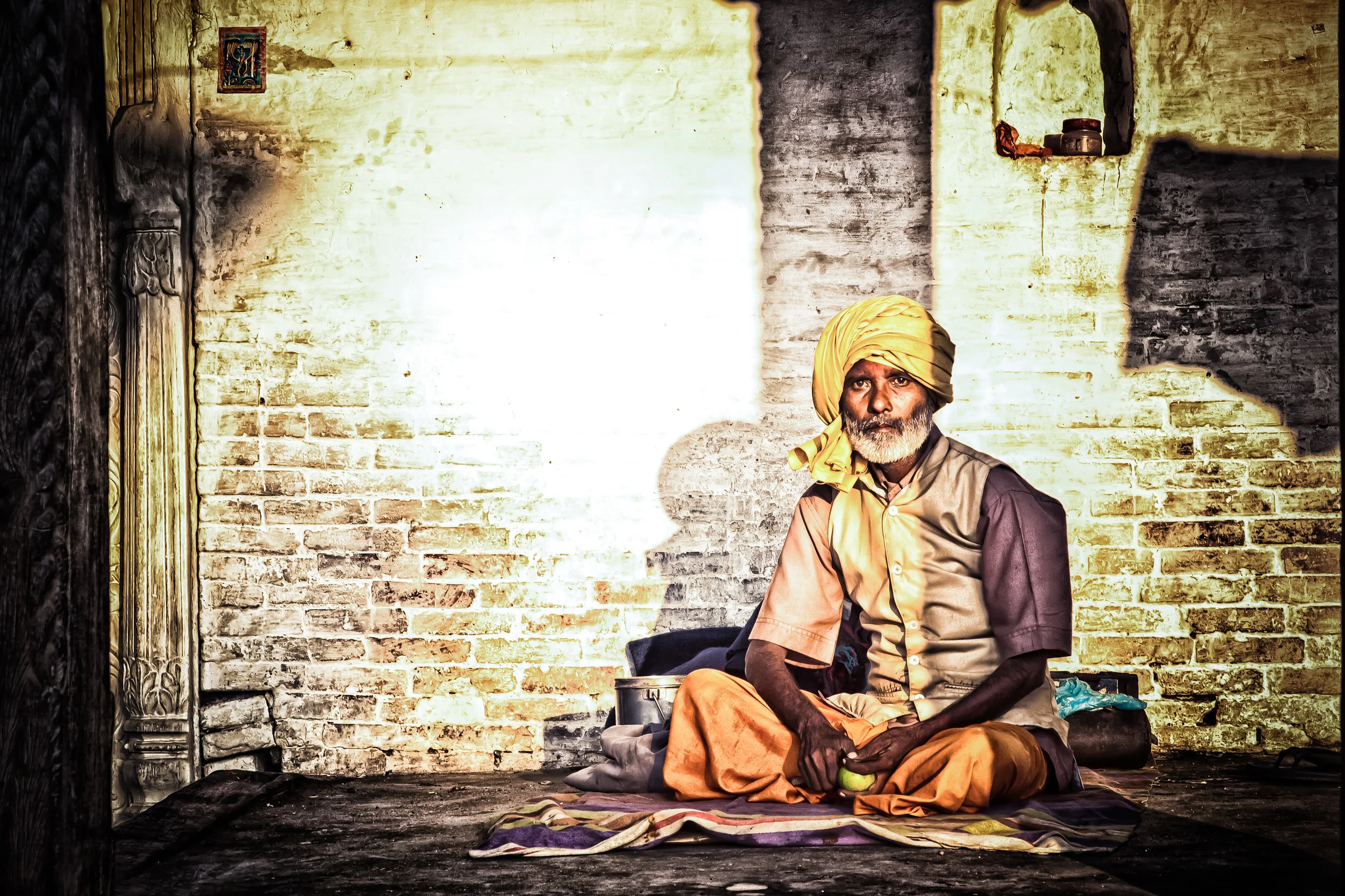 - A Hindu man in Kathmandu preparing to eat an orange outside of a temple. 