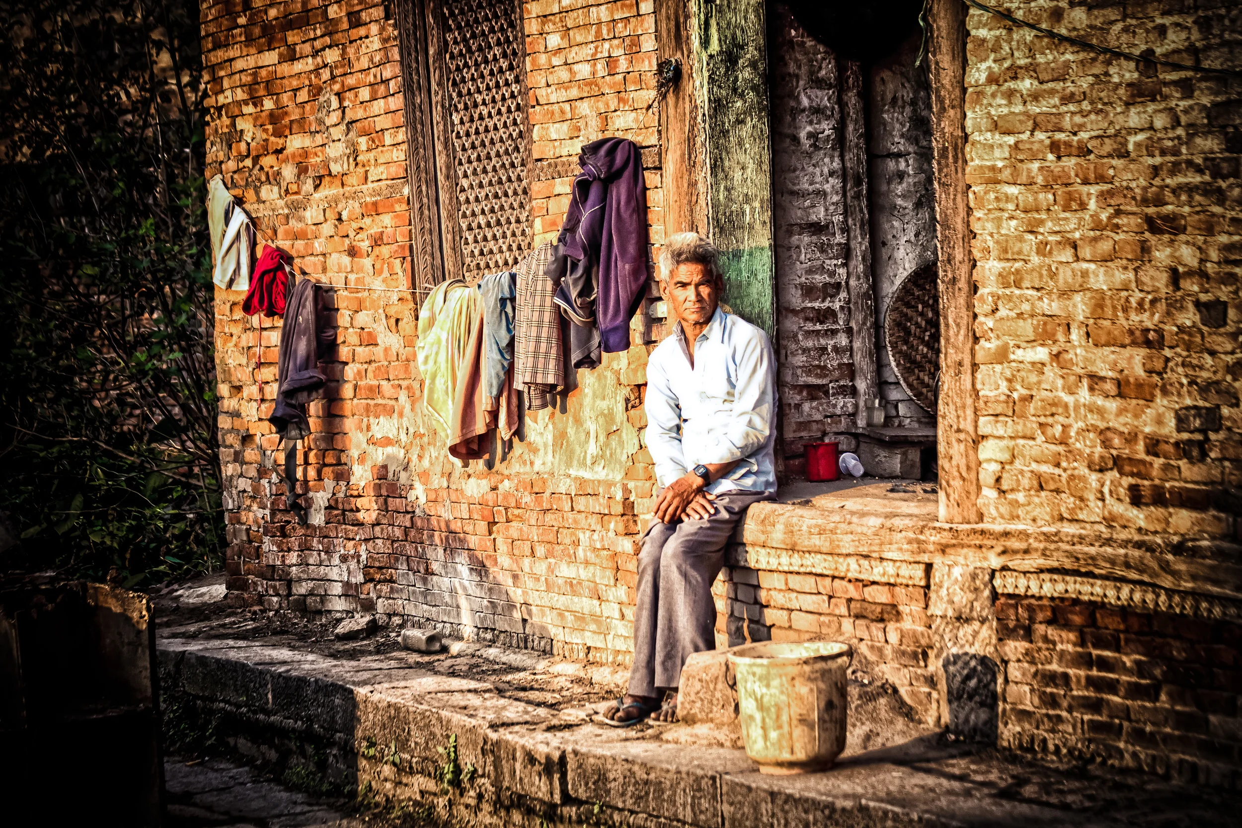- A Nepali man outside of his house in Kathmandu with his drying clothing. 