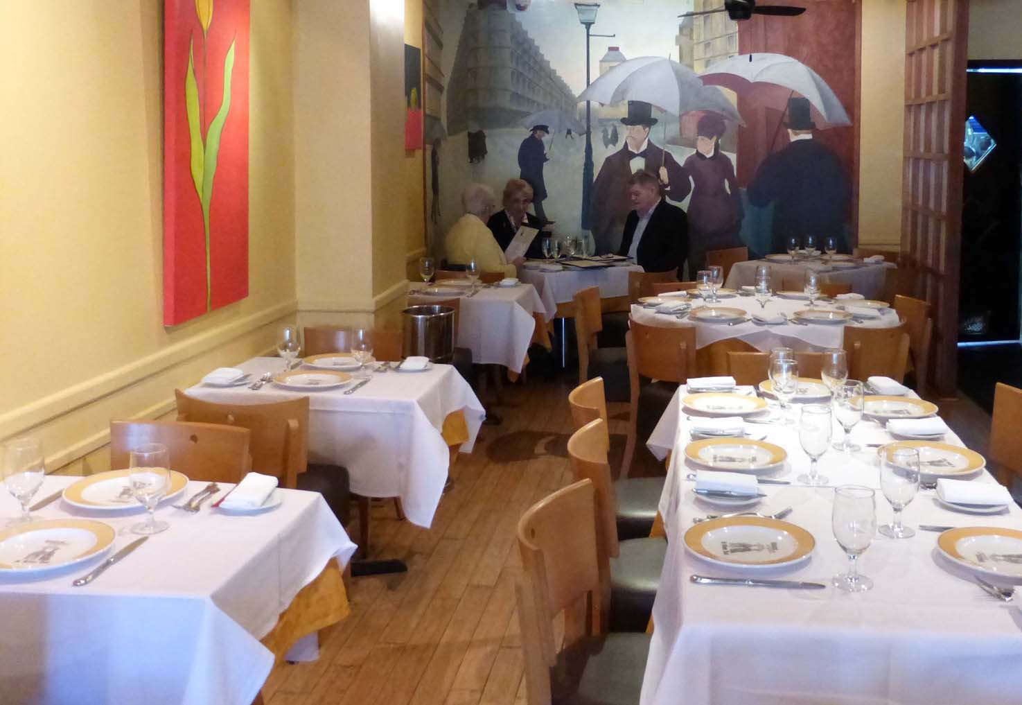 seated by a mural of Caillebotte 's 1877 rainy paris street scene, patrons enjoy an early lunch. photos by ann carper.