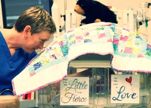 NICU bedside with art and blankets