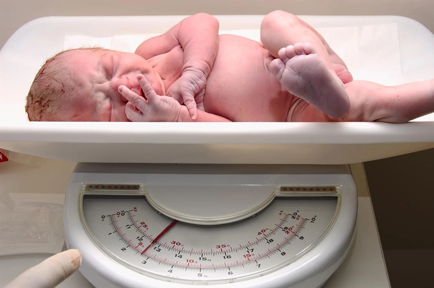 preemie baby newborn on scale in NICU