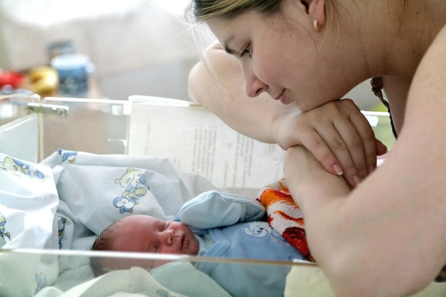 NICU mom looking at NICU baby in crib