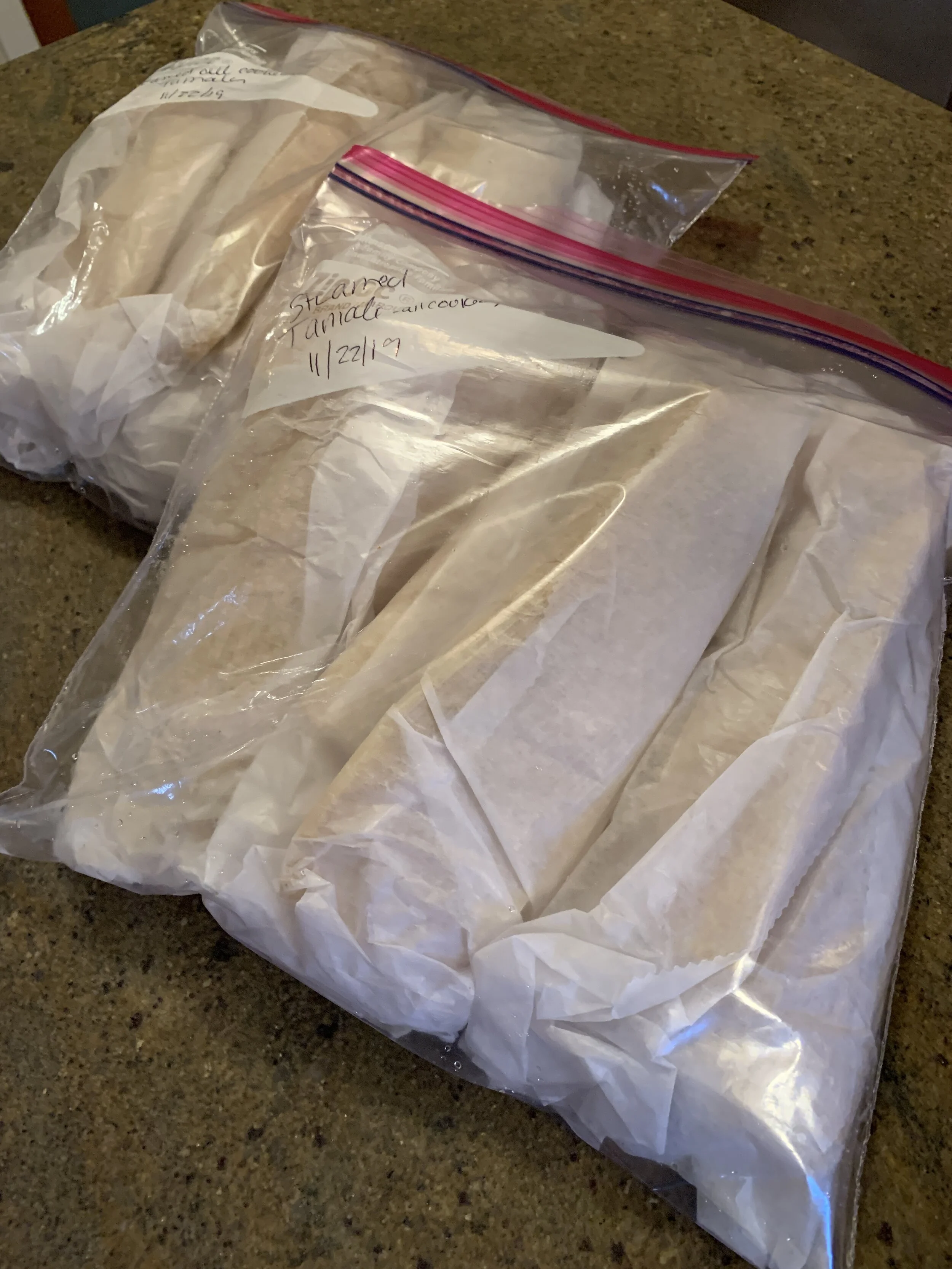 Tamales in wax paper ready to freeze.JPG