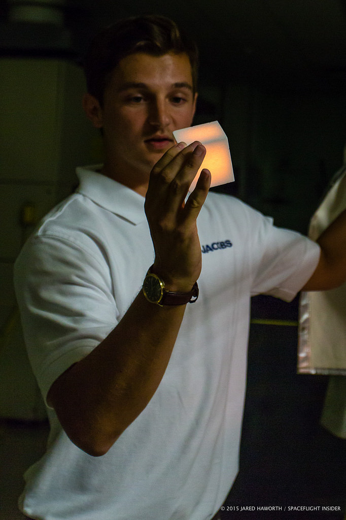 A TPSF employee handles a glowing hot Shuttle tile.