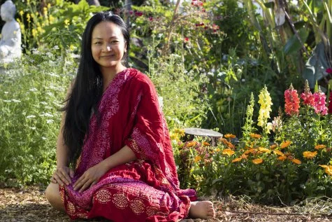 Laura Som, survivor of the Cambodian genocide and founder of the MAYE Center, sits in the community garden surrounding the MAYE Center on East Anaheim Streura Som, sur
