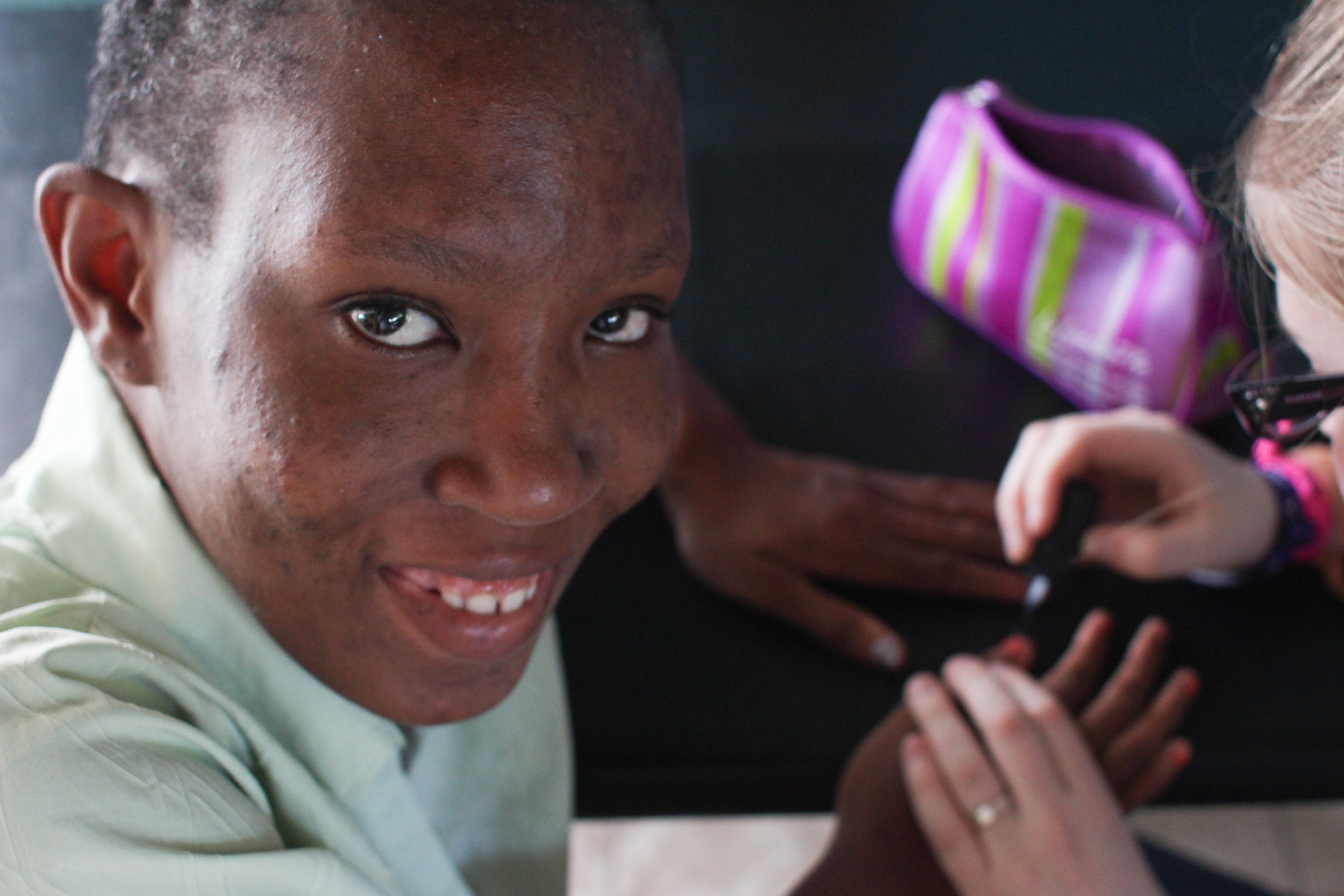 One of the residents at Jacob's Well has her hands painted by one of the volunteers from our group.