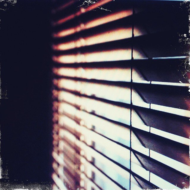 And in the middle of her hurried sleep,
shuttering blinds leak 
voices from the back-lot 
mumblings of night.