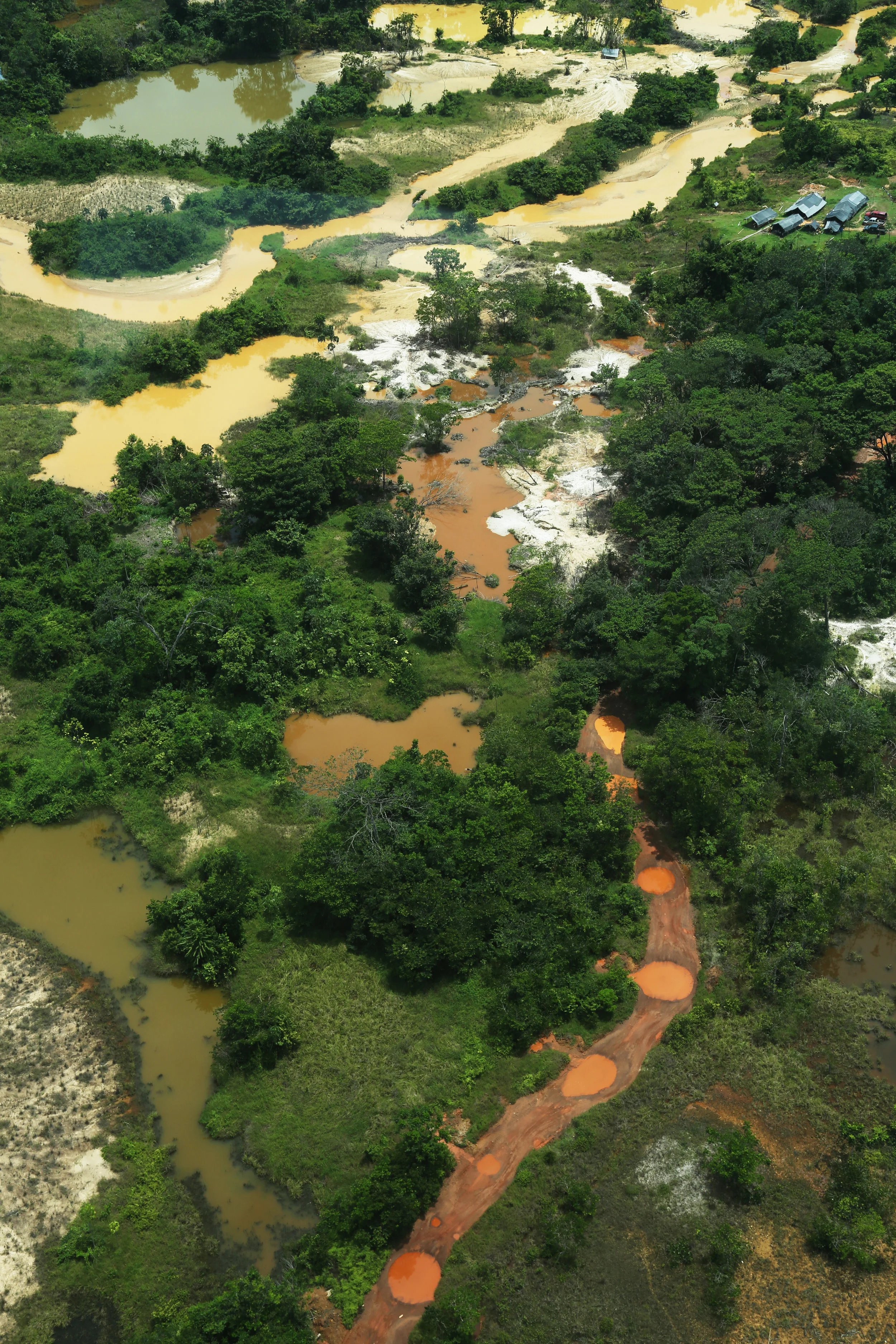AERIAL OF A GOLD MINING SITE: BECAUSE GUYANA HAS NOT TAPPED INTO THE OIL AND GAS ENERGY SECTOR DUE TO ITS NEIGHBORS BEING VENEZUELA, MINING IS ONE OF THE LARGEST EXTRACTIVE INDUSTRIES WITHIN GUYANA. 