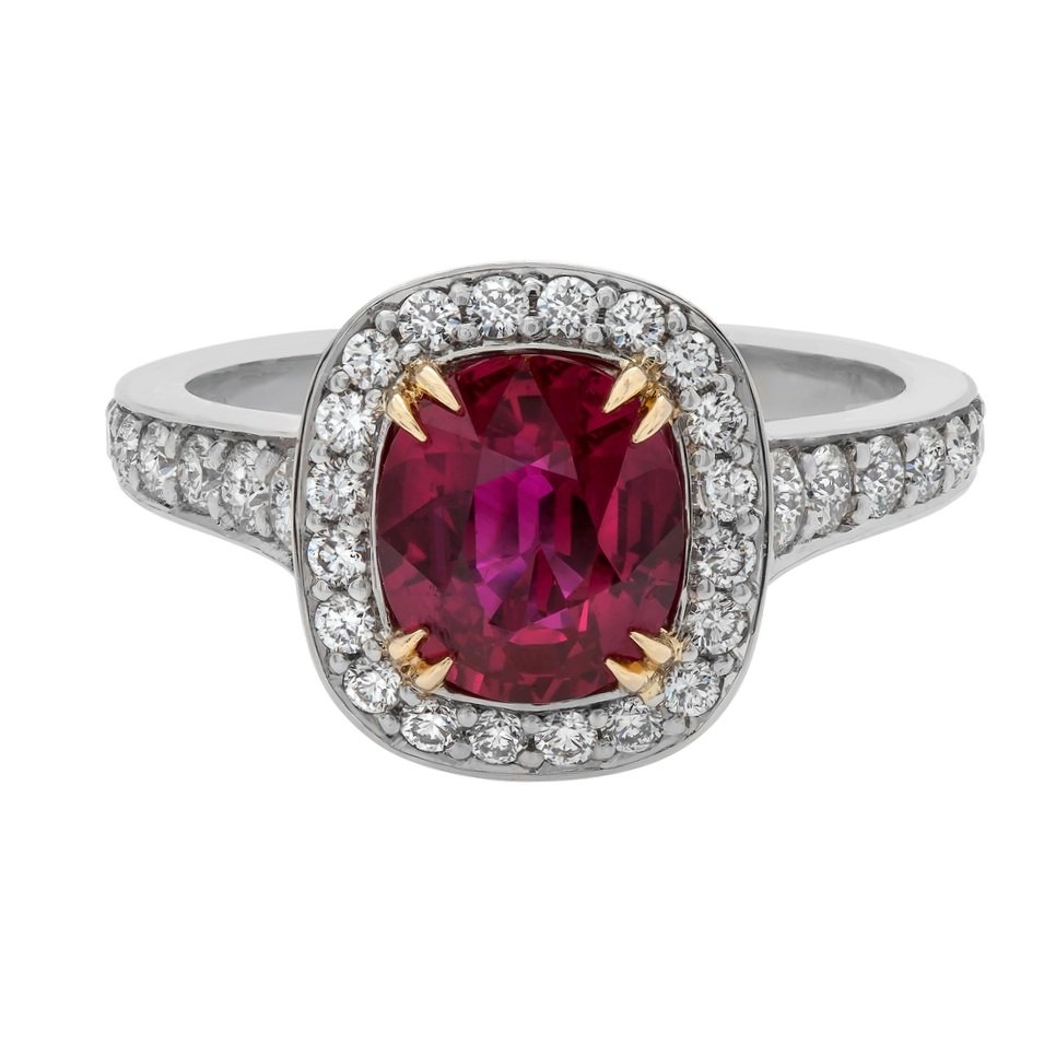 2.12 carat Oval Cut Ruby Ring. 0.77 carats of Round Brilliant Cut Diamonds surround the center stone. Set in 18k yellow gold and platinum.