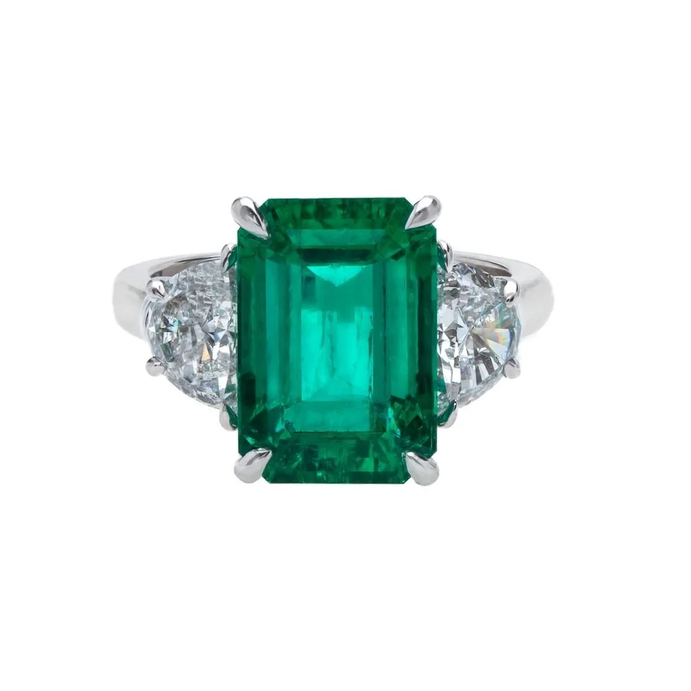 6.14 carat Emerald Cut Columbian Emerald 3 stone Ring. 1.37 carats of Half-Moon Cut Diamonds surround the center stone. Set in platinum.