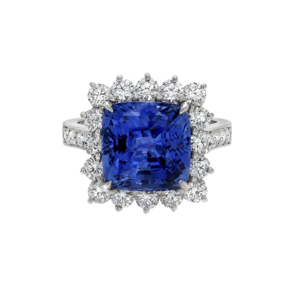 8.10 carat Square Cushion Cut Sapphire Ring. Surrounding the center stone are 1.55 carats of Round Brilliant Cut Diamonds. Set in platinum. 