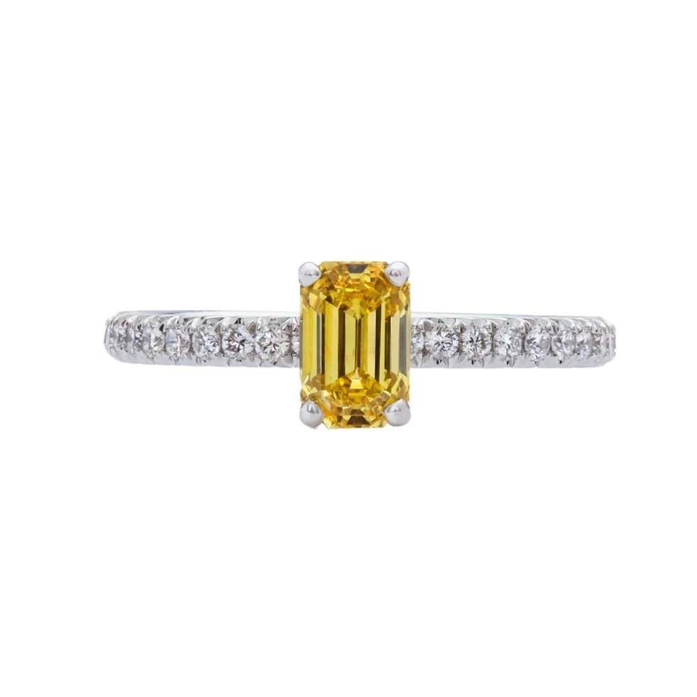 0.78 carat Emerald Cut Fancy Vivid Yellow Diamond Ring. 0.42 carats of Round Brilliant Cut Diamonds on the band. 1.20 carat total weight. Set in platinum.