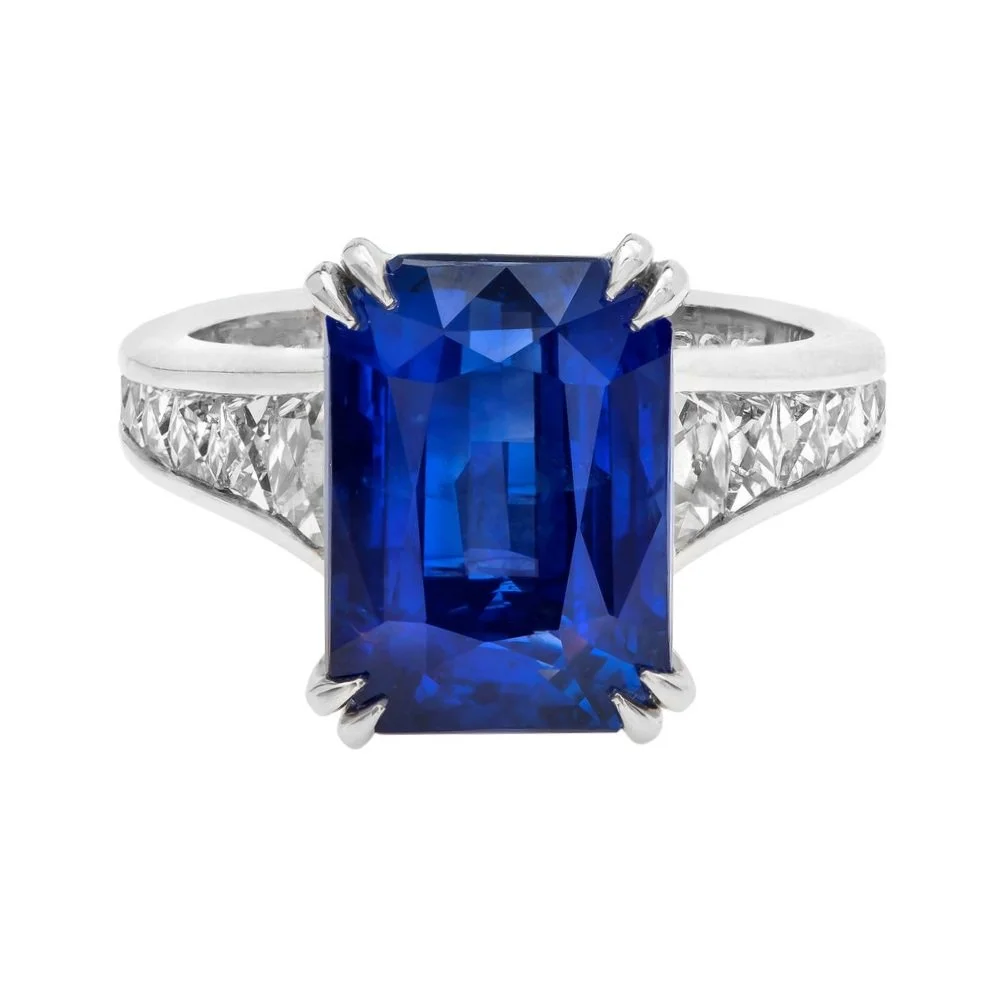 9.03 carat Emerald Cut Sapphire Ring. Surrounding the center stone are 1.24 carats of French Cut Diamonds. Set in platinum. 