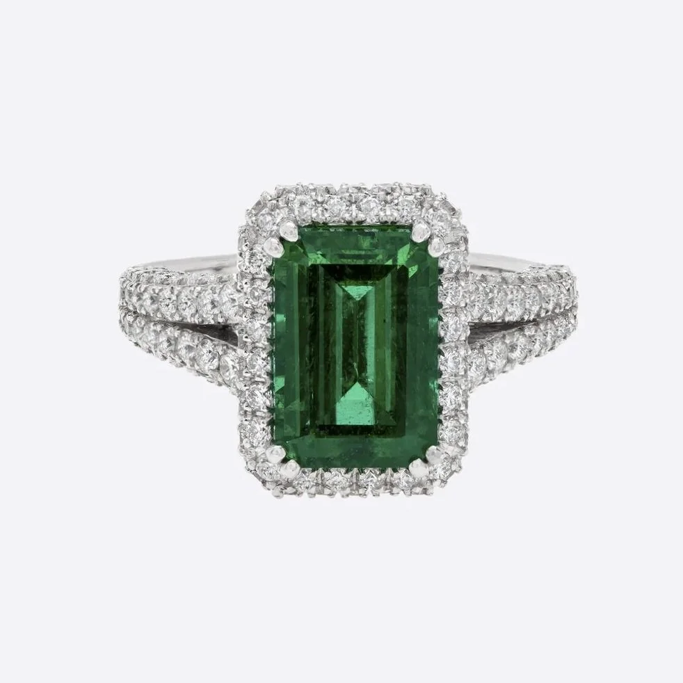 3.55 carat Emerald Cut Emerald Ring. 2.04 carats of Round Brilliant Cut Diamonds surround the center stone. Set in platinum. 