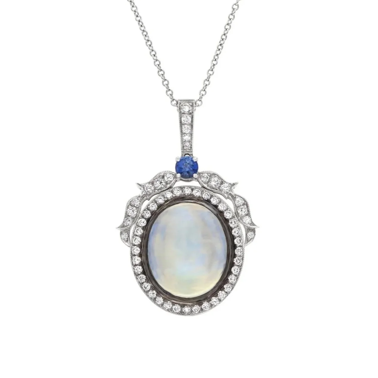 12.17 carat Oval Moonstone Pendant. Surrounding the Moonstone are .63 carats of Round Brilliant Cut Diamonds and a .22 carat Round Sapphire. Set in 18k white gold.
