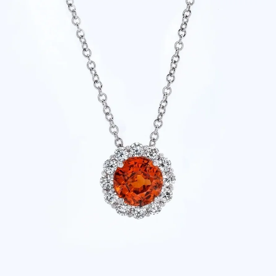 3.22 carat Round Garnet Pendant. 0.69 carats of Round Brilliant Cut Diamonds surround the center stone. 3.91 carats total weight. Set in 18k white gold.