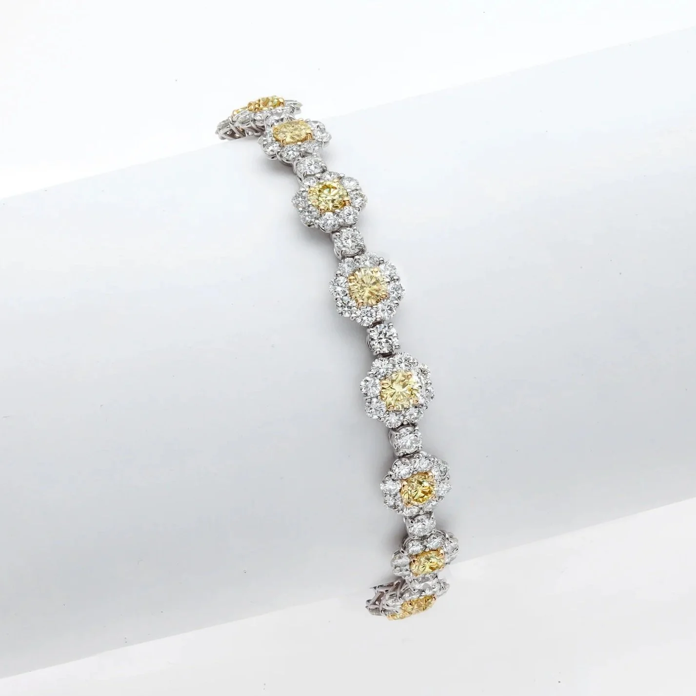 Yellow and White Diamond Cluster Bracelet; 18.42 carat total weight in Round Brilliant Cut Fancy Yellow and White Diamonds. Set in platinum.