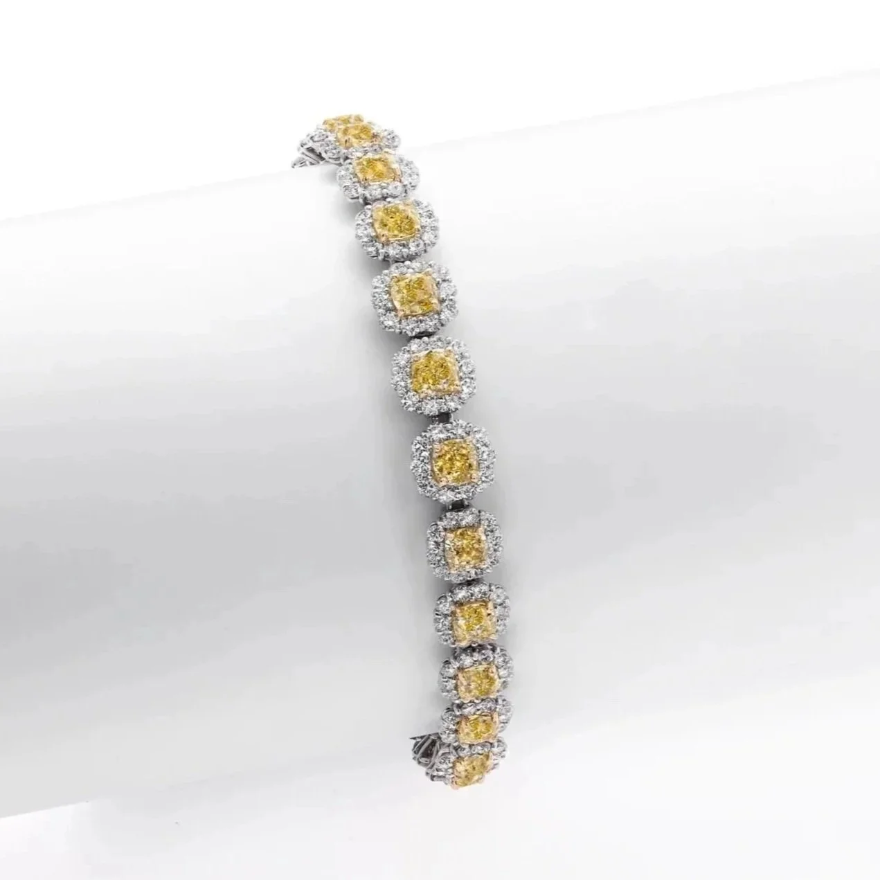 Fancy Yellow and White Diamond Cluster Bracelet; 12.95 carats of Cushion Cut Fancy Yellow Diamonds and 7.07 carats of Round Brilliant Cut Diamonds. Set in platinum. 