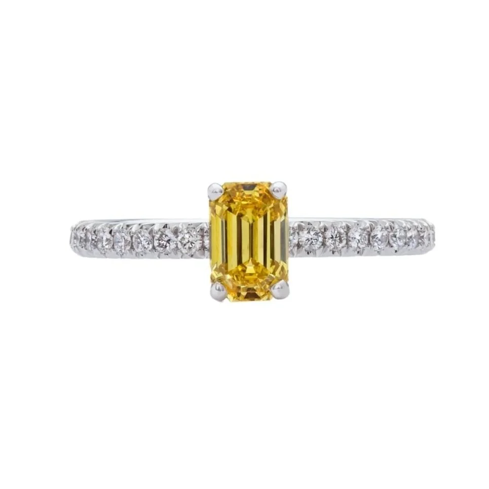 0.78 carat Emerald Cut Fancy Vivid Yellow Diamond Ring. 0.42 carats of Round Brilliant Cut Diamonds on the band. 1.20 carat total weight. Set in platinum.