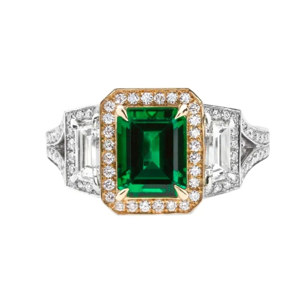 1.86 carat Emerald Cut Emerald Ring. 1.01 carats of Trapezoid and Round Brilliant Cut Diamonds surround the center stone. Set in 18k yellow gold and platinum.