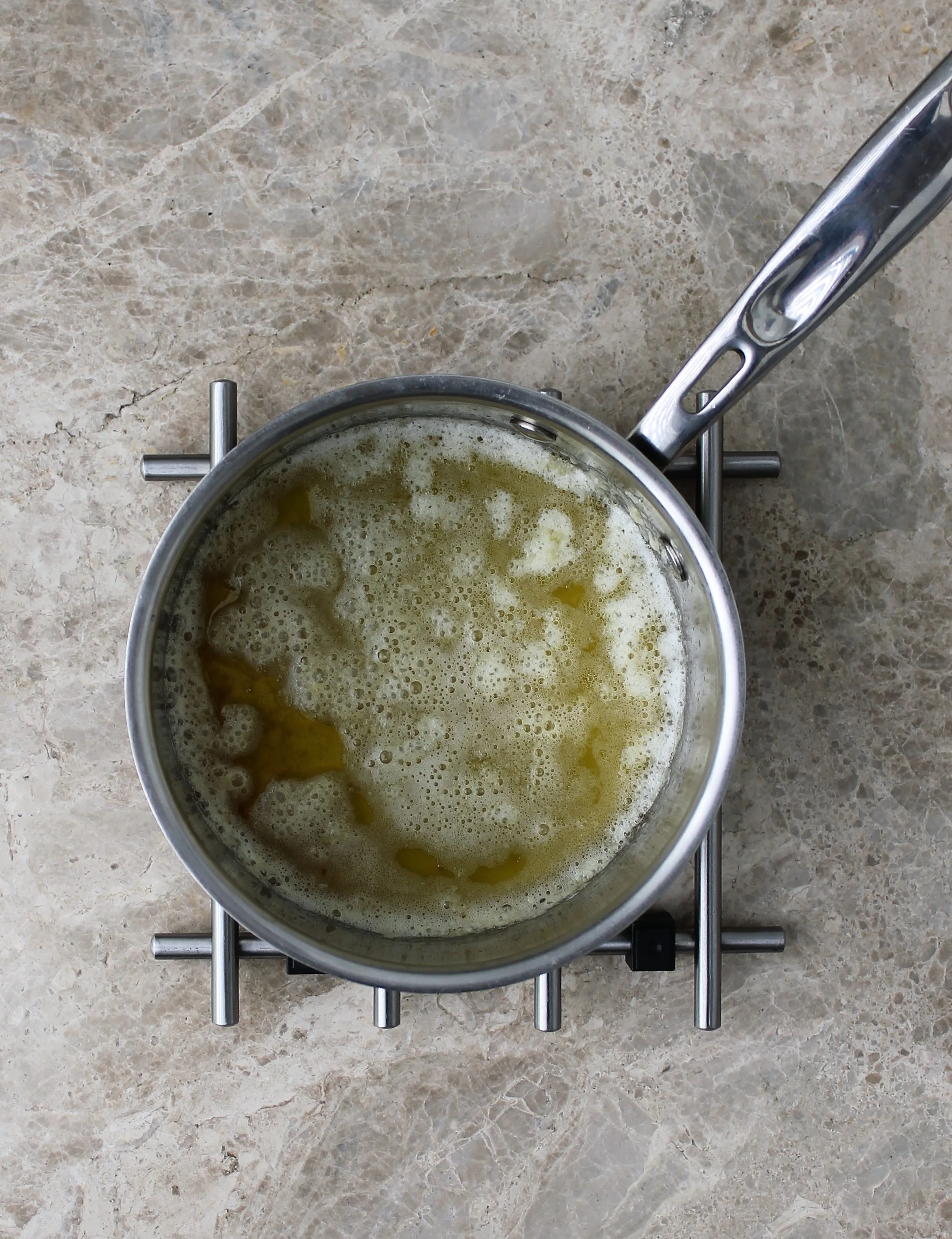 Halfway through cooking, foaming, sputtering, milk solids starting to collect at bottom.