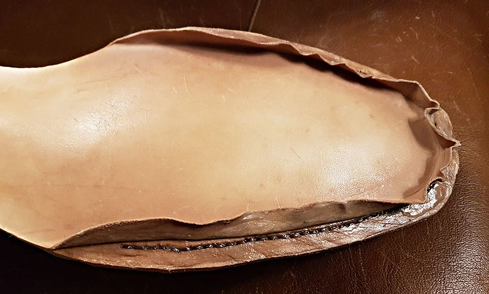 A small flap is cut for the stitching to be done, before sealing the outsole.