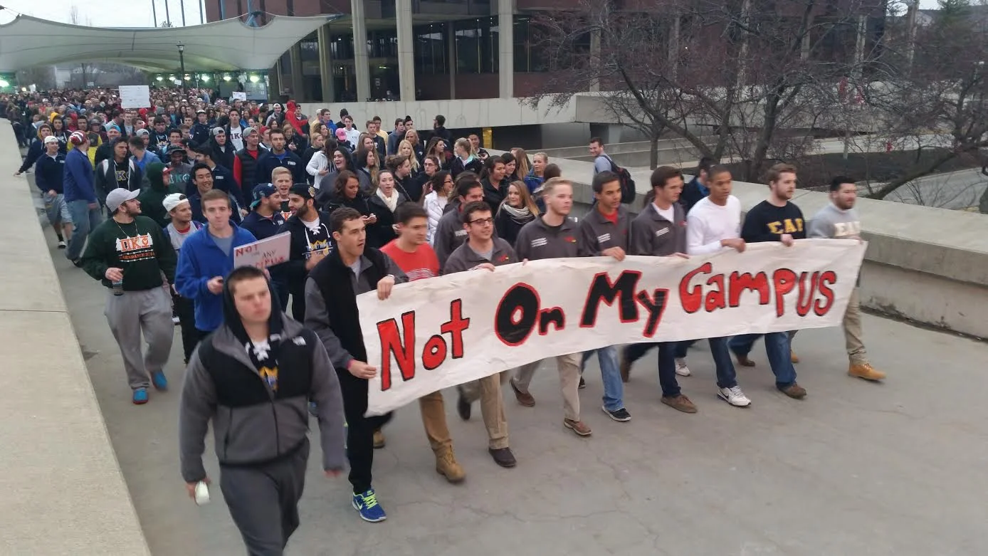 Concerns about racism and inappropriate conduct among fraternities at the national level, as well as alarm over racist student-originated social media posts following recent police protests led Illinois State University administrators and students in spring 2015 to take a hard look at attitudes and diversity. Here, ISU Greek organizations march across campus with a message echoing NIOT:B/N's.