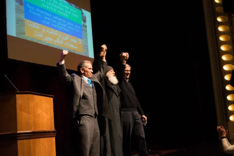 Bloomington Mayor Tari Renner joining hands with Bloomington's Imam Abu-Emad Al-Talla and Mayor Chris Koos of Normal. (Photo by Cristian Jaramillo/WGLT)