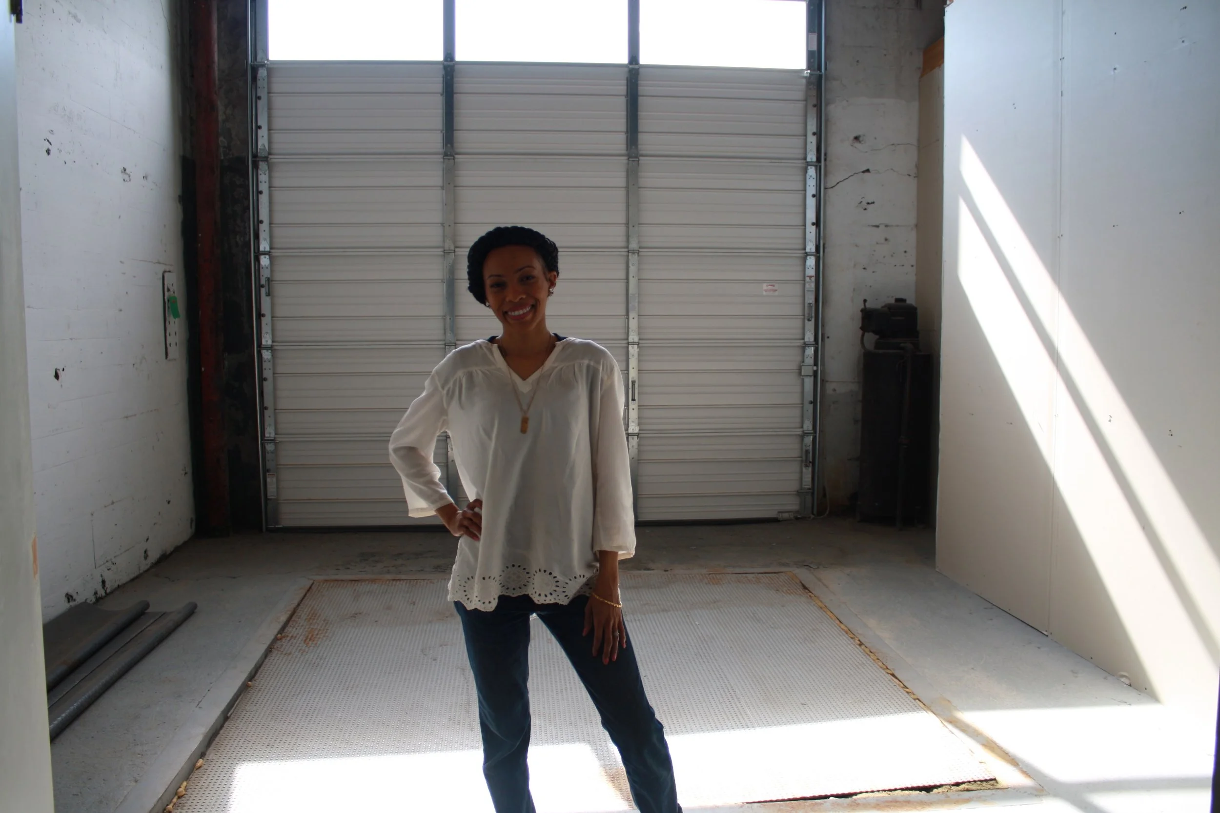 Yasmeen is shown standing inside the loading dock of the space for her food hub, which is designed to store and develop food products for last mile distribution