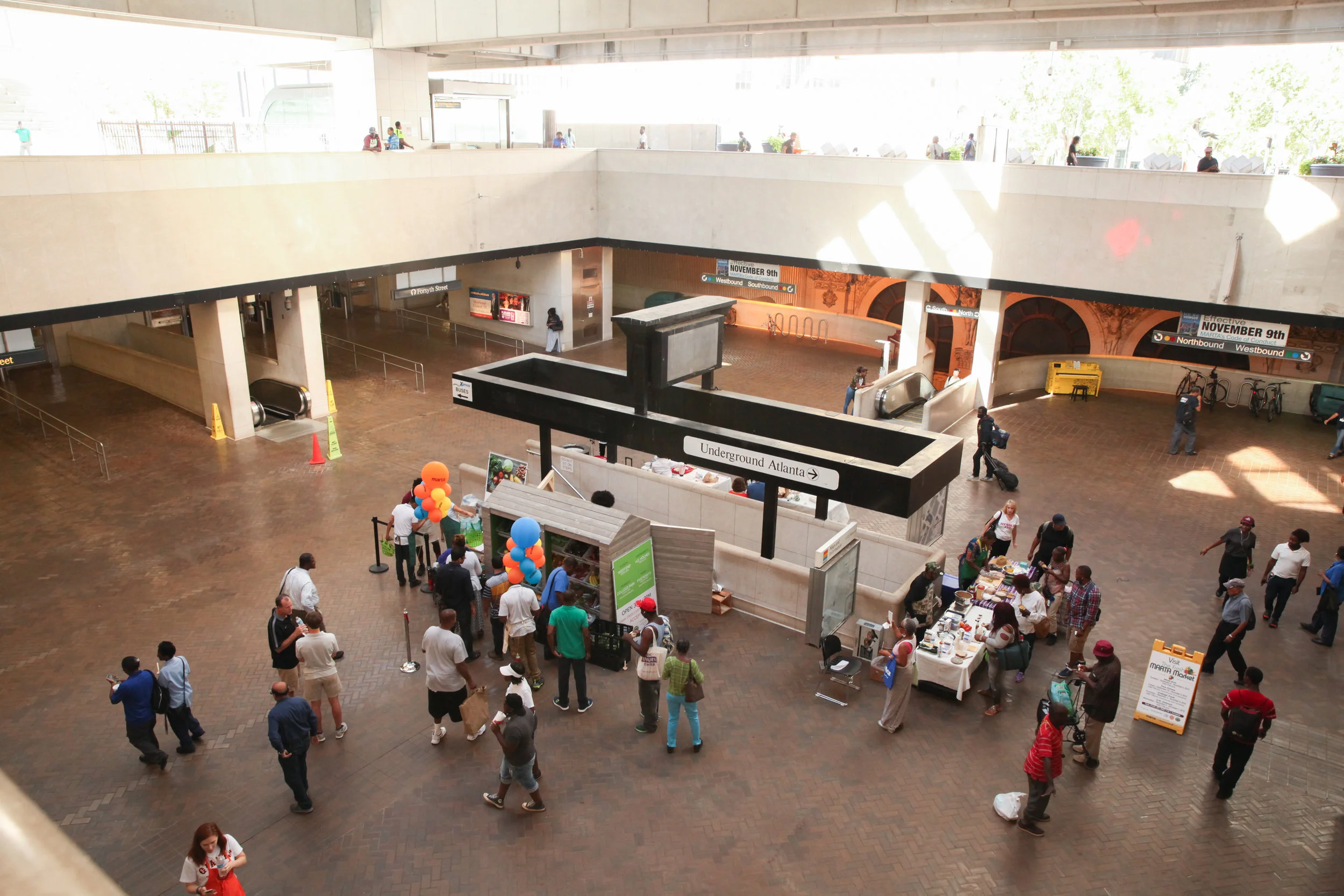 Patrons visit a Fresh MARTA Market stand featuring fresh produce inside a MARTA station