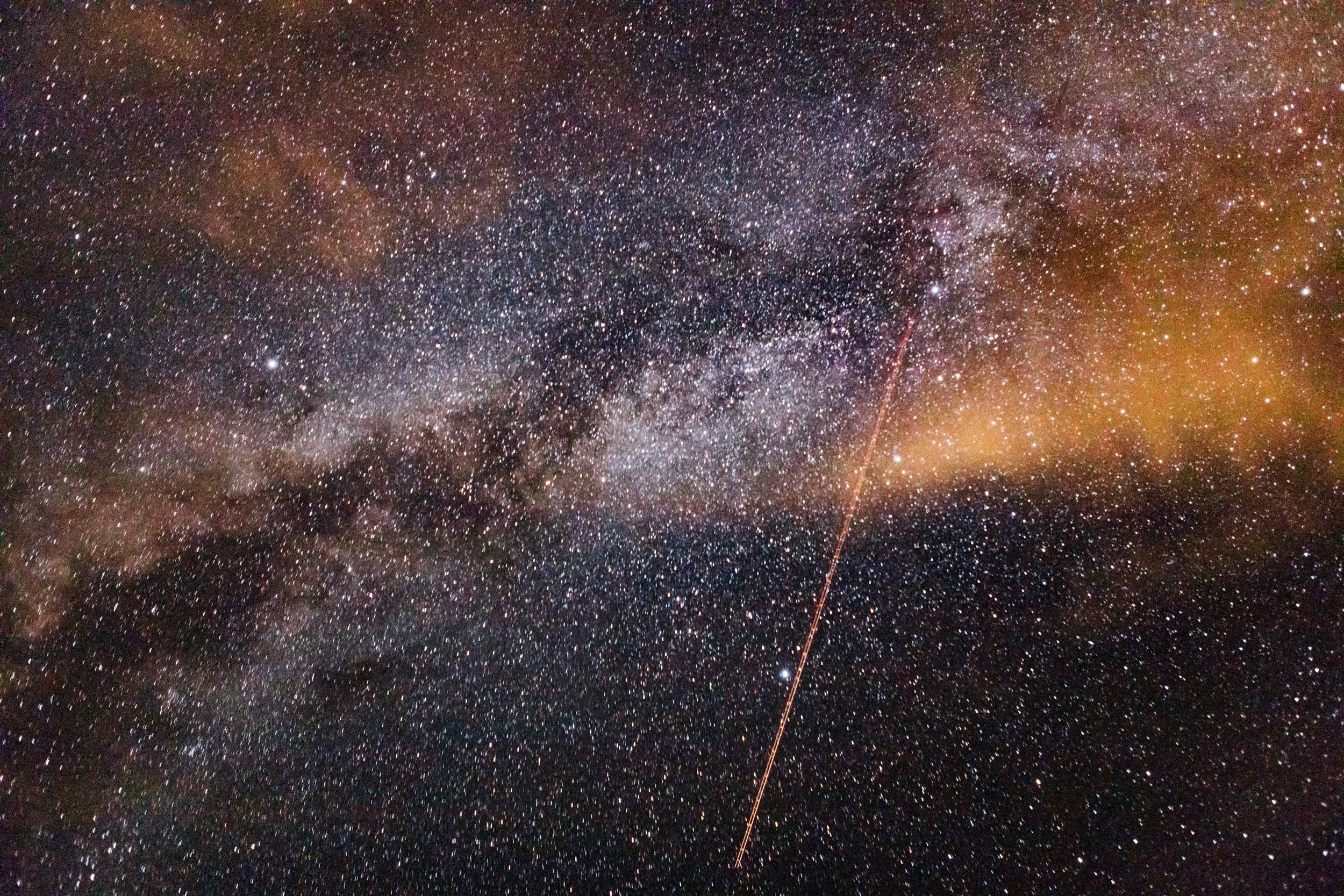 Milky Way galaxy with an airplane trail