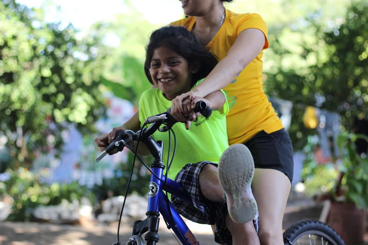 Karen riding her bike with Daniella, a full time employee of the Children of Love Foundation (photo by Mallory Lehenbauer).