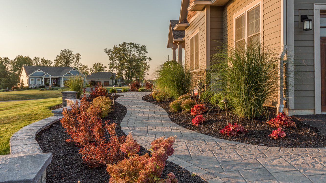 Hardscaping Syracuse NY natural stone walkway with layered landscape plantings