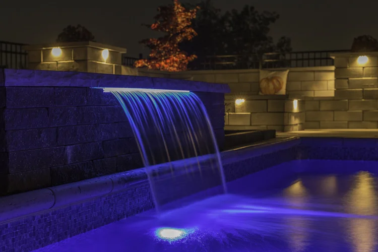Illuminated water feature cascading into a pool in Syracuse NY