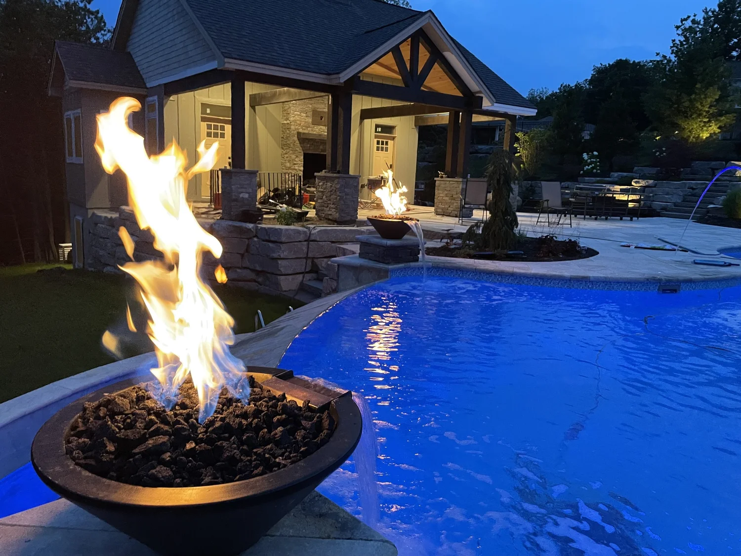 Fire bowls on the edge of a luxury in-ground pool in Central NY