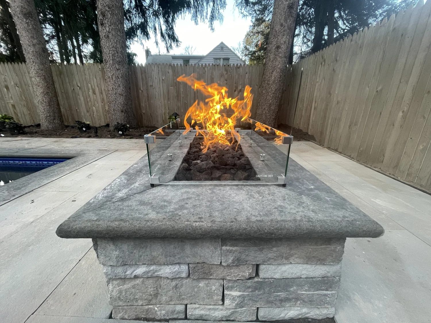 Fire pit installation Syracuse NY modern masonry gas fire pit with glass